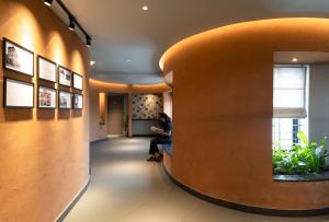 una mujer sentada en un pasillo en un edificio en YMCA International Guest House, en Trichūr