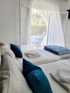 a room with three beds with blue pillows at Kalimera Studios and Apartments in Moraitika +26 photos