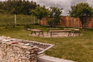 un parque con 2 mesas de picnic y una pared de piedra en Dzikowiejsko en Bardo