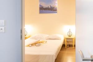 a bedroom with a bed with white sheets at Printemps chaleureux T4 +2 place de parking privée in Annecy
