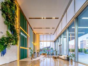 EVEN Hotel Qingdao Laoshan - an IHG Hotel في تشينغداو: لوبي مبنى عليه نباتات على الجدران