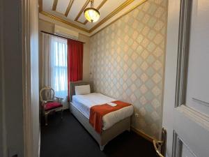 a small bedroom with a bed and a window at Le Safran Suite Hotel in Istanbul