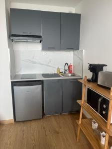 a small kitchen with a sink and a stove at Appartement vue mer in Sète