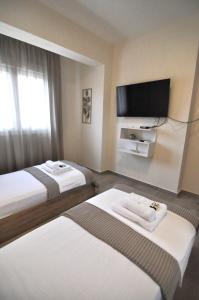 una camera d'albergo con due letti e una TV a schermo piatto di Zennova #60, Nikiti Family Apt a Skála Nikíta