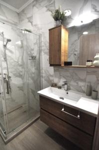 un bagno con doccia in vetro e lavandino di Zennova #60, Nikiti Family Apt a Skála Nikíta