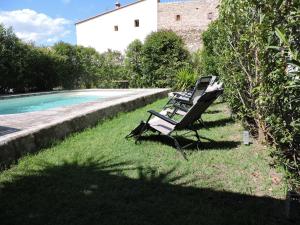 two lounge chairs sitting in the grass next to a pool at Arum in Codalet