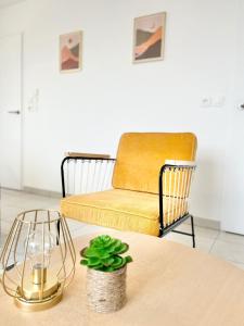 ein Wohnzimmer mit einem Stuhl und einem Tisch in der Unterkunft Superbe T2 gare Annemasse avec Garage et balcon in Ville-la-Grand