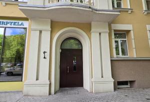 un edificio con una puerta con una cruz. en Urban studio apartment, en Klaipėda