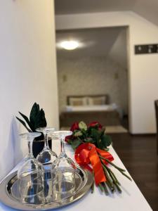stół z dwoma kieliszkami do wina i kwiatami w obiekcie Pensiunea Sub Horiță w mieście Leordina