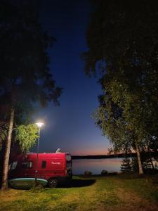 een rode truck geparkeerd naast een straatlicht bij Marjoniemi Camping in Hiidenniemi