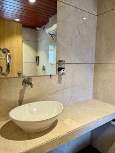 W łazience znajduje się umywalka i lustro. w obiekcie Hotel Galaxy w Bombaju
