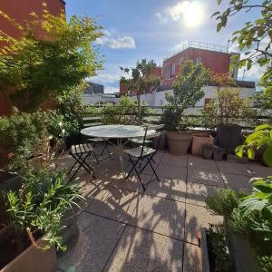 un patio con mesa, sillas y plantas en Appartement avec terrasse, en Saint-Denis