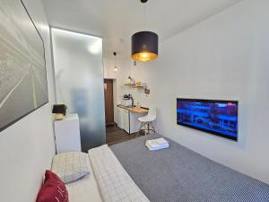 Habitación con cama y TV en la pared. en Urban studio apartment, en Klaipėda