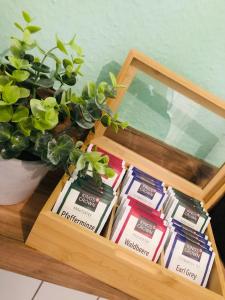 a wooden box with packets of tea in it with a potted plant at Zentrale 1 1/2 Zimmer Apartment in Wolfsburg