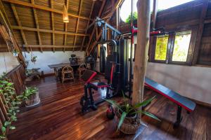 a gym with exercise equipment in a room with wooden floors at Shambala Madagascar: Beachfront Lodge And Adventures in Ambolobozo