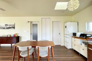 a kitchen with a table and chairs in a room at Surf Cottage KATAKAI-九十九里 片貝海岸- in Kujukuri