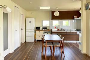 a kitchen with a table and chairs in a room at Surf Cottage KATAKAI-九十九里 片貝海岸- in Kujukuri