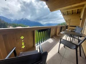 a balcony with chairs and tables and a view of mountains at Das Aparthotel Olympia Tirol in Seefeld in Tirol