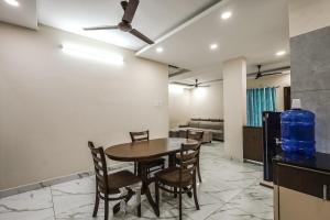 uma sala de jantar com mesa e cadeiras em FabExpress 7 Hills Home Stay em Tirupati