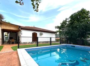 una piscina frente a una casa en Casa rural VISTABLANCA a una sola planta con bonitas vistas y piscina - Junto a la capital y la Alhambra, en Cenes de la Vega