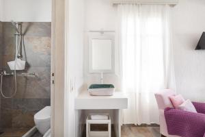 ein Badezimmer mit einem Waschbecken, einem WC und einem Spiegel in der Unterkunft Fos Apartments Mykonos in Agios Ioannis Mykonos