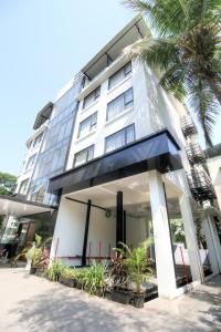 a building with a palm tree in front of it at Hotel Mumbai House Ghansoli, Navi Mumbai in Navi Mumbai