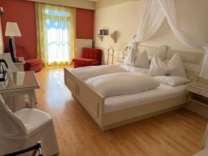 1 dormitorio con 1 cama blanca con dosel en Panoramahotel Steirerland, en Kitzeck im Sausal