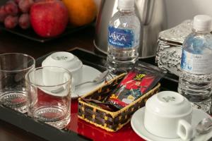 a tray with glasses and water bottles on a table at Hanoi Aria Central Hotel & Spa in Hanoi