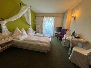 ein Hotelzimmer mit einem Himmelbett in der Unterkunft Panoramahotel Steirerland in Kitzeck im Sausal
