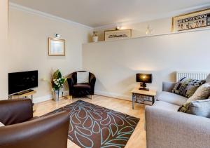 a living room with a couch and a tv at Sunnyhill Mews in Torquay