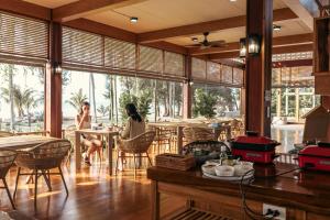 Dos mujeres sentadas en mesas en un restaurante en Thammachard29 Resort Baangrood, en Thong Chai