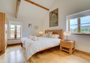 1 dormitorio con 1 cama grande y 2 ventanas en Farmlands en St Merryn
