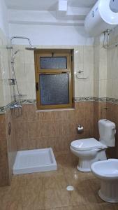 łazienka z toaletą, umywalką i oknem w obiekcie Dream Home w mieście Pogradec