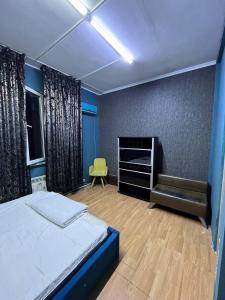 - une chambre avec un lit et une chaise verte dans l'établissement City hostel Almaty, à Almaty 3 autres photos