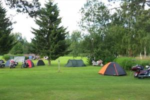 een groep tenten en motorfietsen geparkeerd in een veld bij Marjoniemi Camping in Hiidenniemi