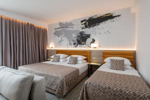 um quarto de hotel com duas camas e um quadro na parede em Hotel Ivka em Dubrovnik