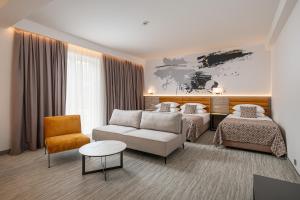 ein Hotelzimmer mit zwei Betten und einer Couch in der Unterkunft Hotel Ivka in Dubrovnik