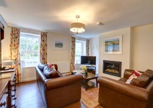 uma sala de estar com dois sofás e uma lareira em Hen Ysgol em Beaumaris