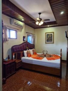 a bedroom with a bed with an orange comforter at Sakura Wood House in Luang Prabang