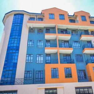 a tall building with orange and blue windows at Alpha homes in Nakuru