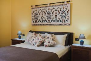 Schlafzimmer mit einem Bett mit Kissen und Wandteppich in der Unterkunft B&B L'Albero Dei Limoni in Portoscuso