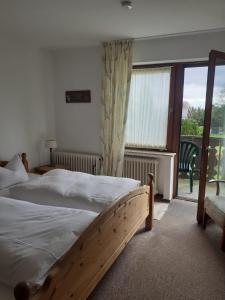 1 Schlafzimmer mit 2 Betten und einem großen Fenster in der Unterkunft Pension Hubertus in Winterberg