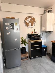 a kitchen with a refrigerator and a microwave at Maison de famille in Lormont