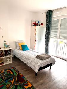 a bedroom with a bed and a refrigerator at Maison de famille in Lormont