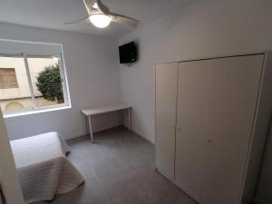 a room with a bed and a cabinet and a window at El Hostalito in Ontinyent