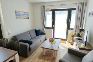 un salon avec un canapé et une table dans l'établissement Sonnendeck No 11 - Aurora Vista - ABC533 - nur Feriengäste!, à Hohen Wieschendorf