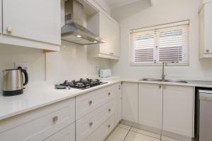 a kitchen with white cabinets and a stove at San Lameer Villa 2609 - 3 Bedroom Superior - 6 pax - San Lameer Rental Agency in Southbroom