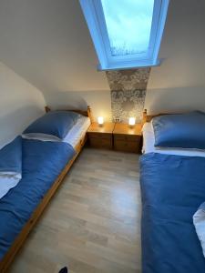 two beds in a small room with a window at Ferienwohnung Currle in Wangerland