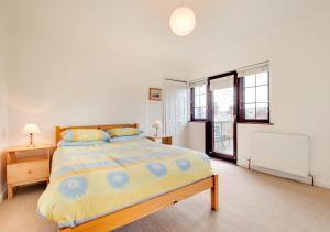 1 dormitorio con 1 cama con colcha amarilla y azul en Dirleton, en Saundersfoot