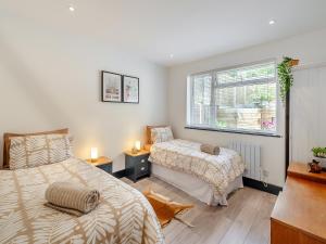 a bedroom with two beds and a window at Seabrook House in Hythe